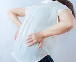 腰痛で腰を押さえている女性