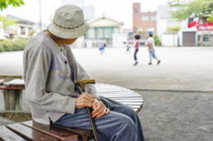 公園でぼんやりする認知症老人の写真